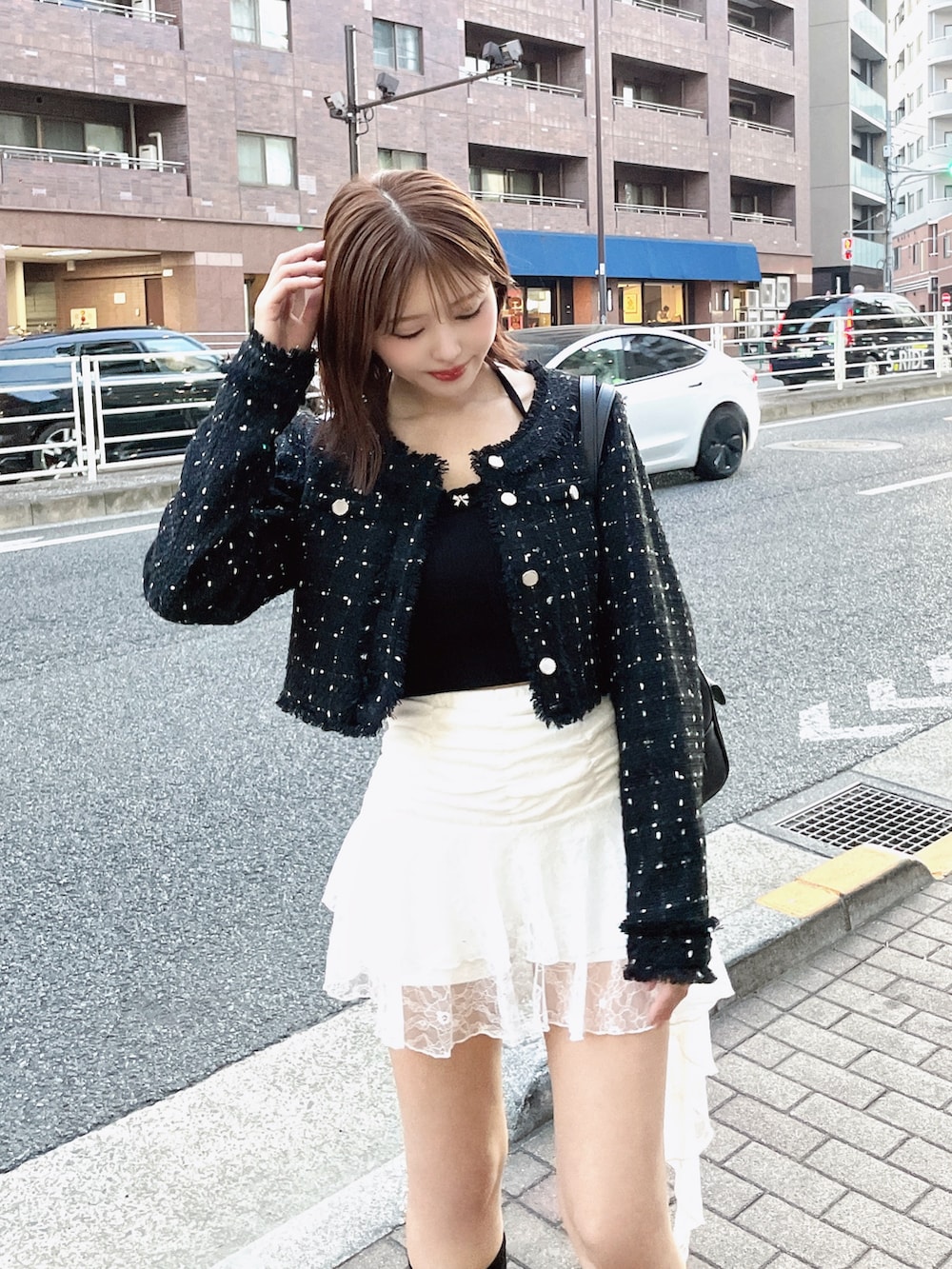 ブラック系のテーラードジャケット、ホワイト系のTシャツ/カットソー、ブラック系のボストンバッグを着用したレディースの春コーディネートの3枚目の写真