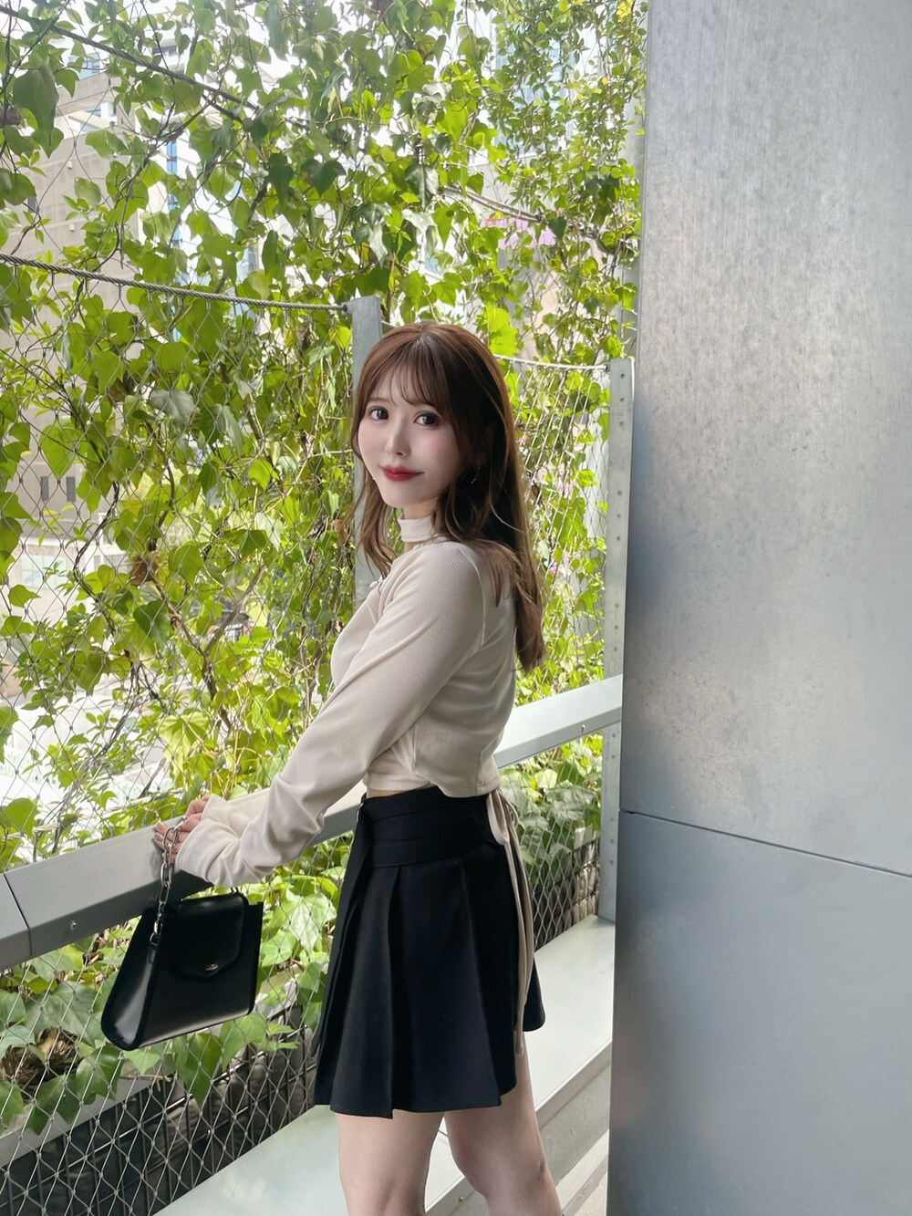 ホワイト系のTシャツ/カットソー、ブラック系のショルダーバッグ、ブラック系のスカートを着用したレディースの秋コーディネートの3枚目の写真