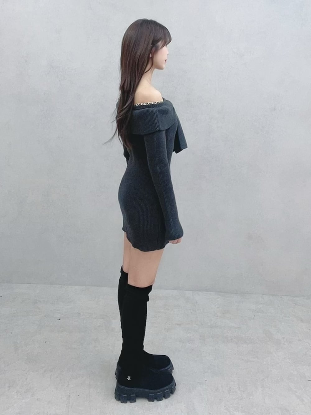 グレー系のワンピース、ブラック系のブーツを着用したレディースの冬コーディネートの3枚目の写真