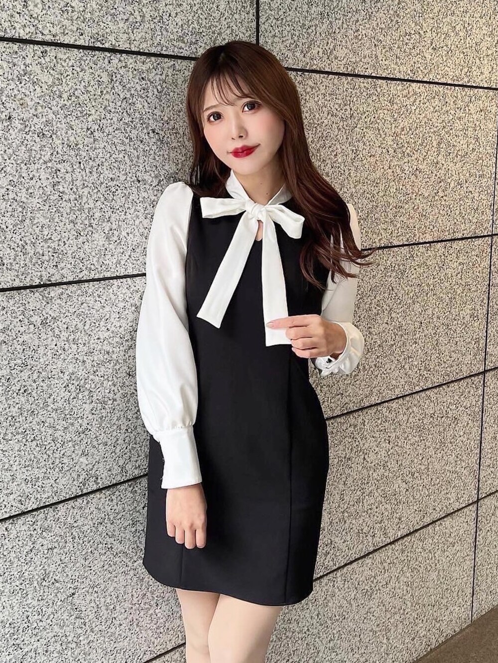 ブラック系のワンピース、ブラック系のハンドバッグ、その他のパンプスを着用したレディースの冬コーディネートの3枚目の写真