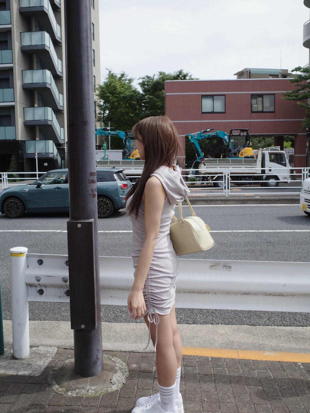 グレー系のワンピース、ホワイト系のスニーカー、イエロー系のボストンバッグを着用したレディースの夏コーディネートの9枚目の写真