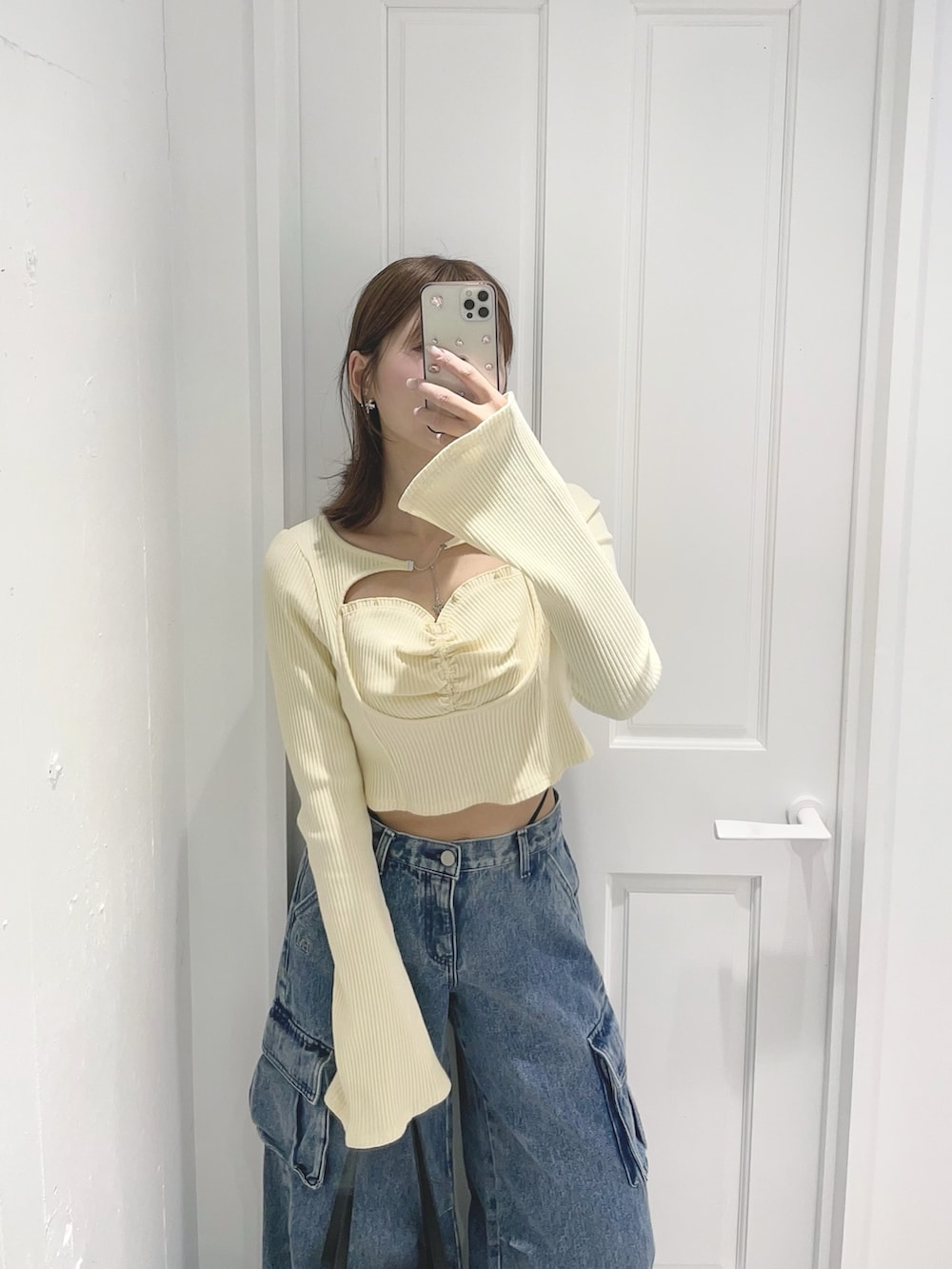 イエロー系のTシャツ/カットソー、ブルー系のデニムパンツ、ブラック系のボストンバッグを着用したレディースの冬コーディネートの3枚目の写真