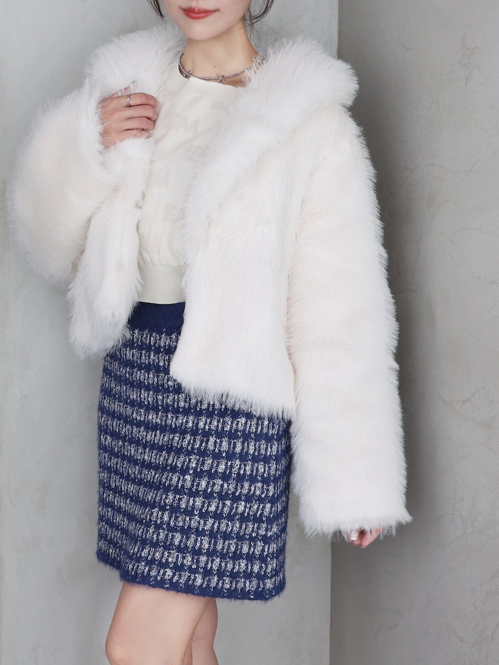 ホワイト系のその他アウター、ホワイト系のニット/セーター、ブルー系のスカートを着用したレディースの秋コーディネートの3枚目の写真