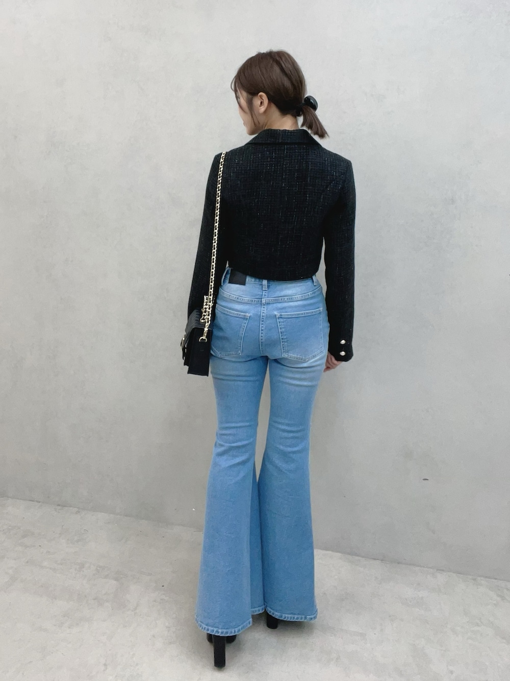 ブルー系のデニムパンツ、ブラック系のサンダル、ブラック系のテーラードジャケットを着用したレディースの秋コーディネートの6枚目の写真