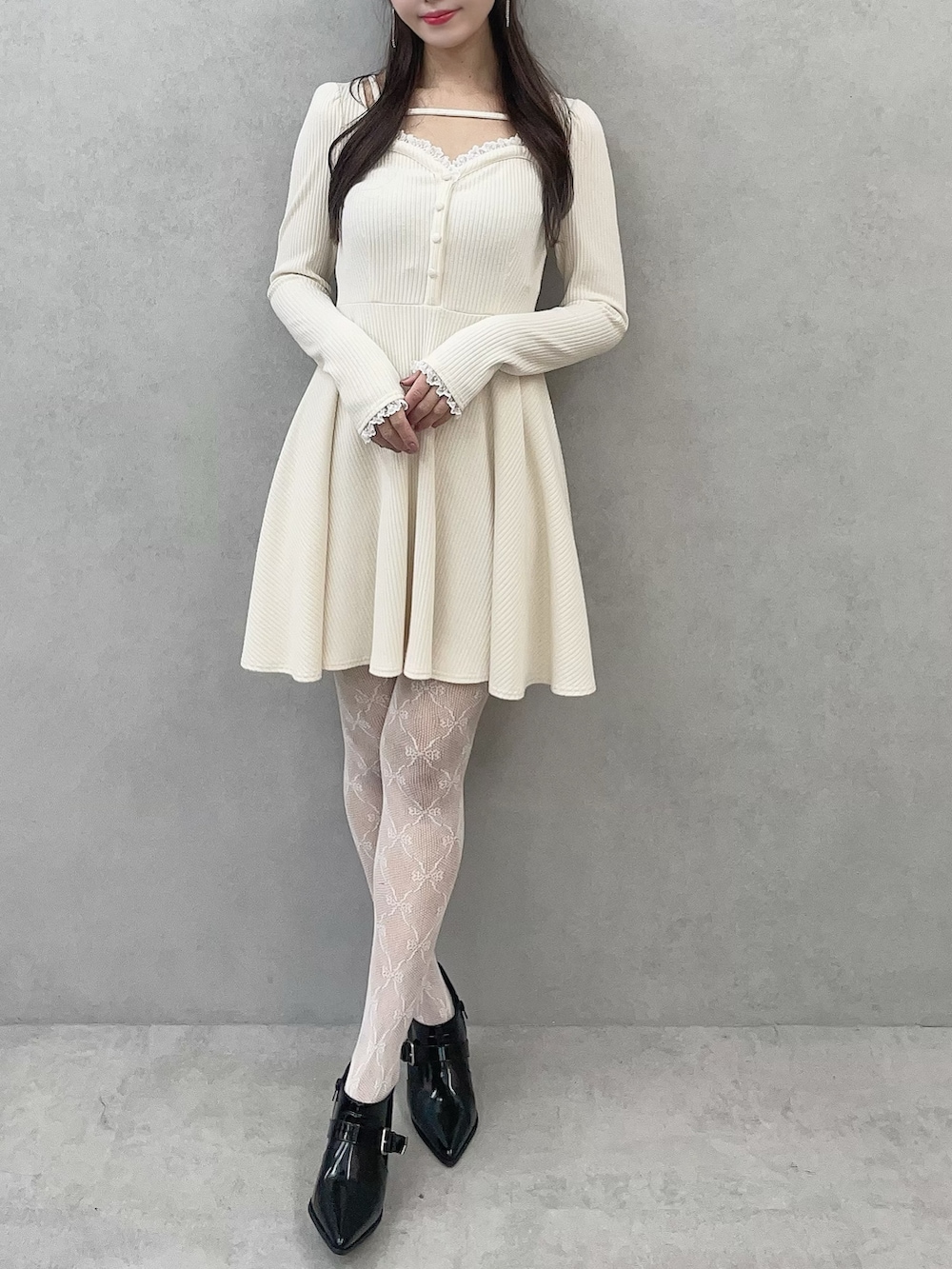 ホワイト系のワンピース、ブラック系のブーツを着用したレディースの冬コーディネートの4枚目の写真