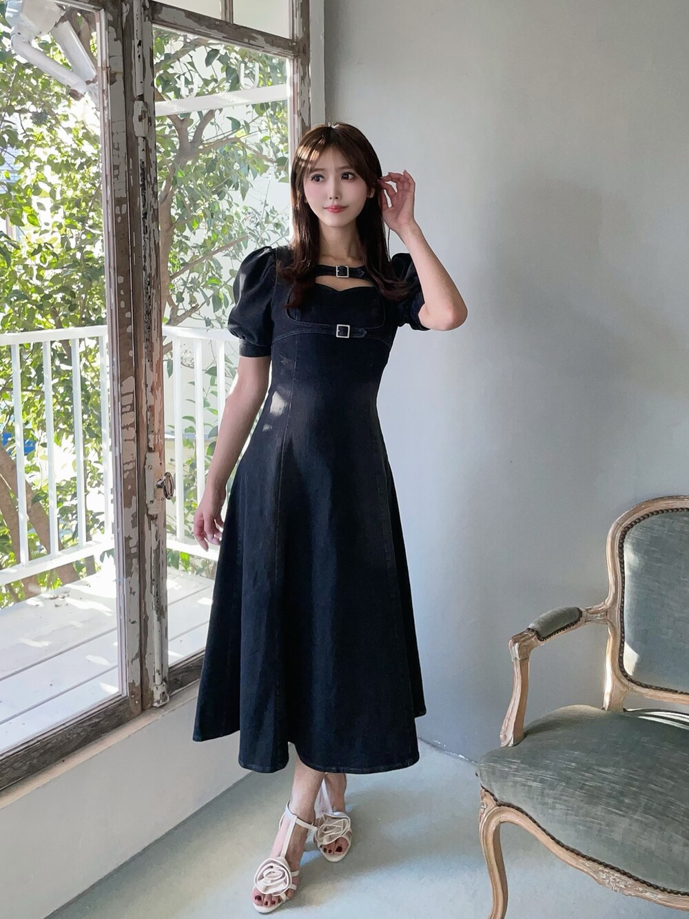 ホワイト系のハンドバッグ、ブラック系のワンピース、ホワイト系のサンダルを着用したレディースの春コーディネートの4枚目の写真