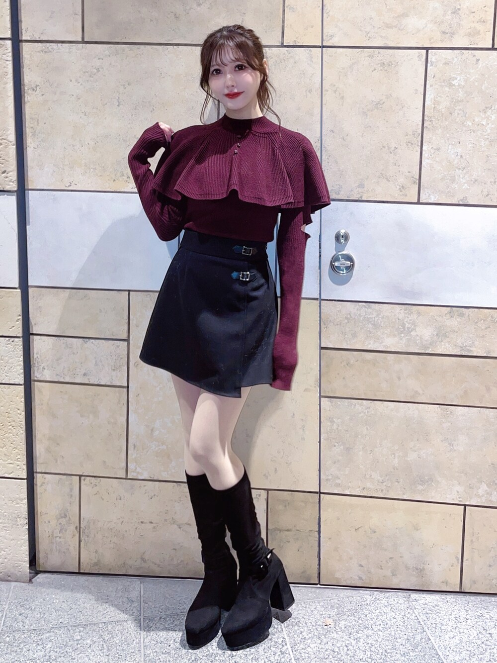 レッド系のニット/セーター、ブラック系のスカートを着用したレディースの冬コーディネートの3枚目の写真