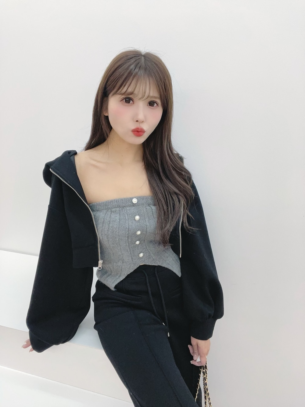 ブラック系のパーカー、ブラック系のバックパック/リュック、グレー系のニット/セーターを着用したレディースの冬コーディネートの7枚目の写真