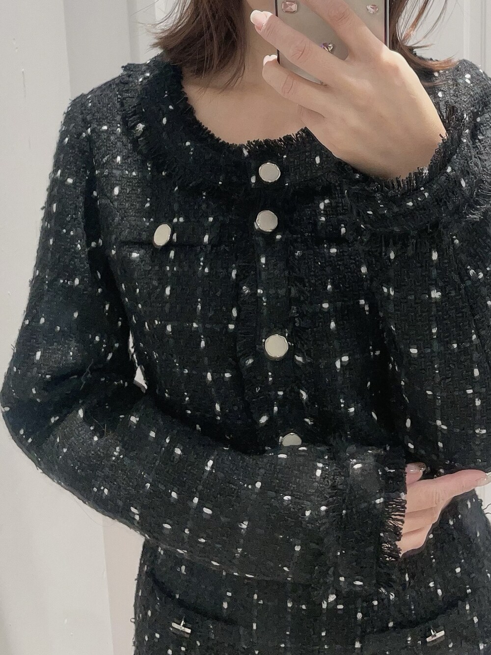 ブラック系のテーラードジャケット、ブラック系のスカートを着用したレディースの冬コーディネートの5枚目の写真