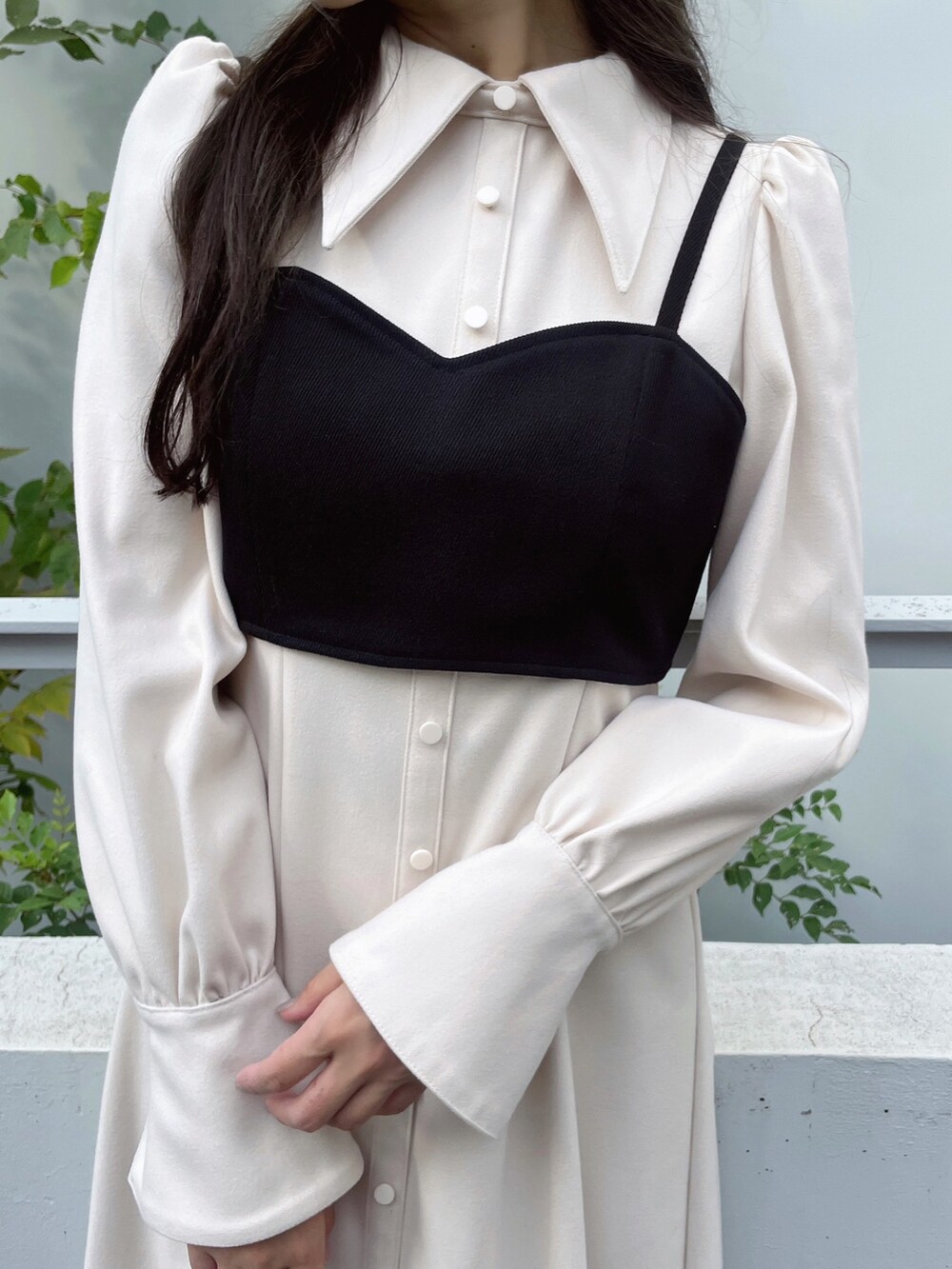 ホワイト系のワンピース、ブラック系のパンプス、ブラック系のピアス（両耳用）を着用したレディースの秋コーディネートの6枚目の写真