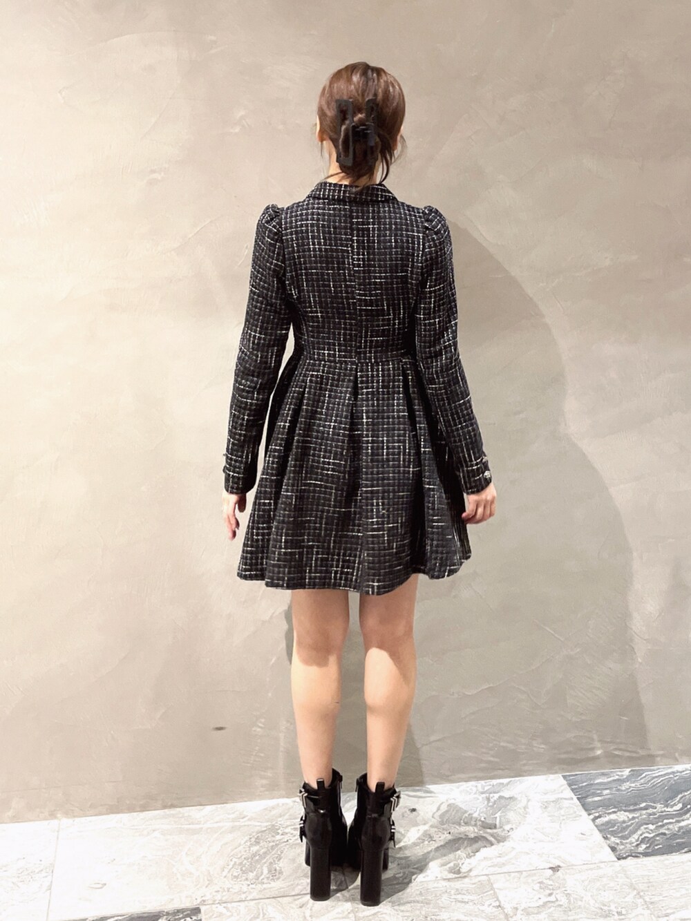 ブラック系のワンピース、ブラック系のブーツを着用したレディースの冬コーディネートの5枚目の写真