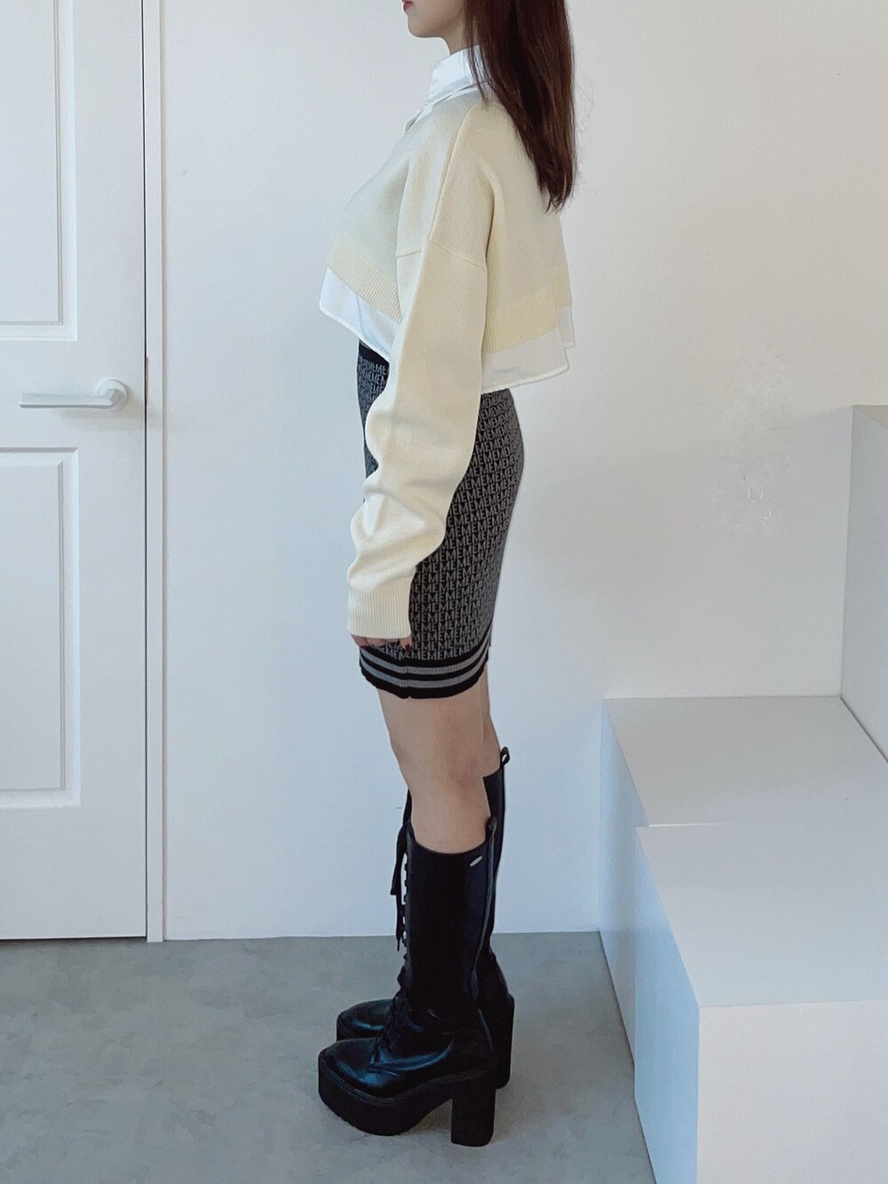 ホワイト系のシャツ/ブラウス、ブラック系のスカート、ブラック系のブーツを着用したレディースの秋コーディネートの7枚目の写真