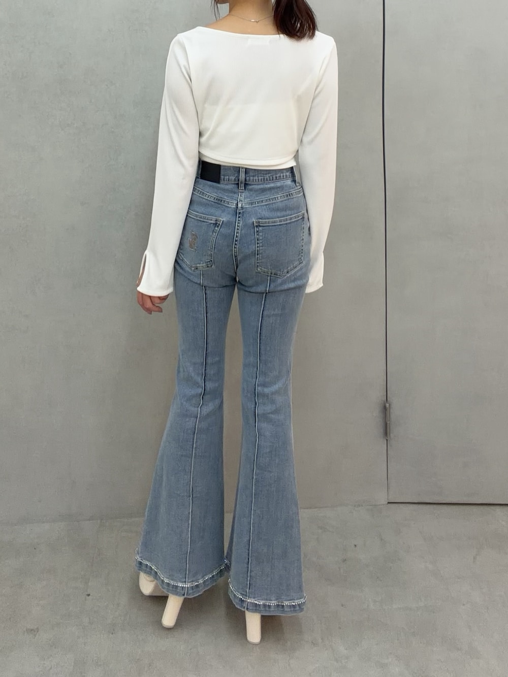 ブルー系のデニムパンツ、ホワイト系のTシャツ/カットソー、ホワイト系のサンダルを着用したレディースの冬コーディネートの5枚目の写真