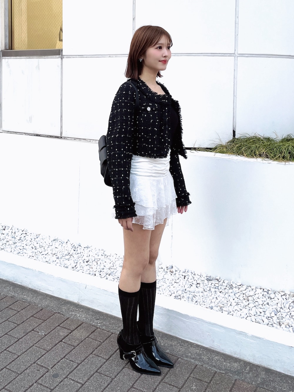 ブラック系のテーラードジャケット、ホワイト系のTシャツ/カットソー、ブラック系のボストンバッグを着用したレディースの春コーディネートの8枚目の写真