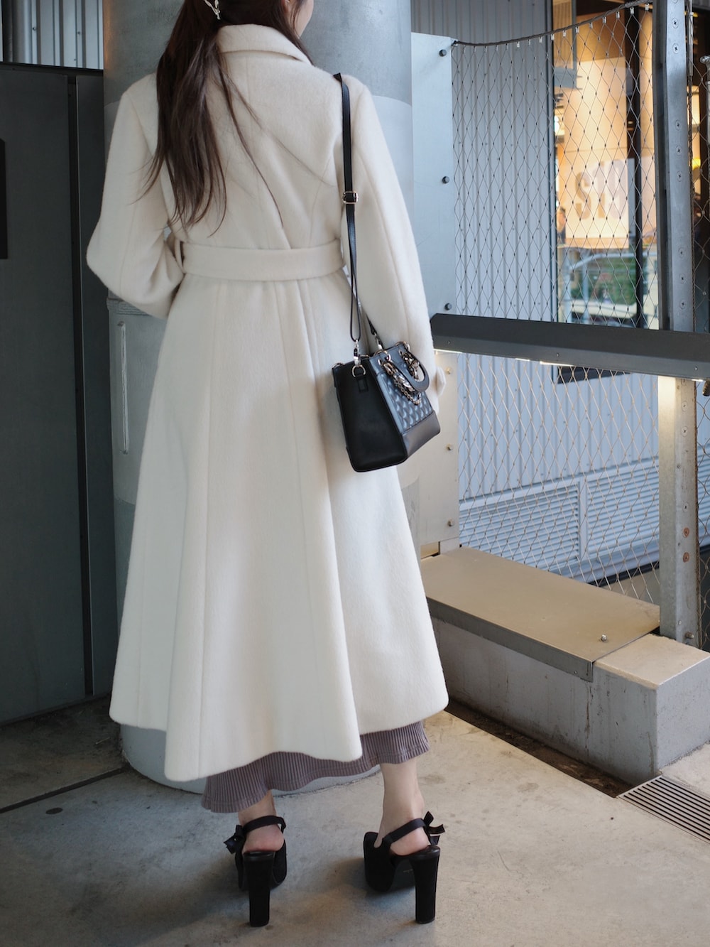 ホワイト系のその他アウター、ブラック系のハンドバッグを着用したレディースの冬コーディネートの3枚目の写真
