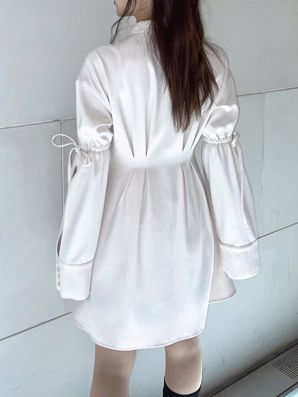 ホワイト系のワンピース、ブラック系のブーツを着用したレディースの冬コーディネートの4枚目の写真