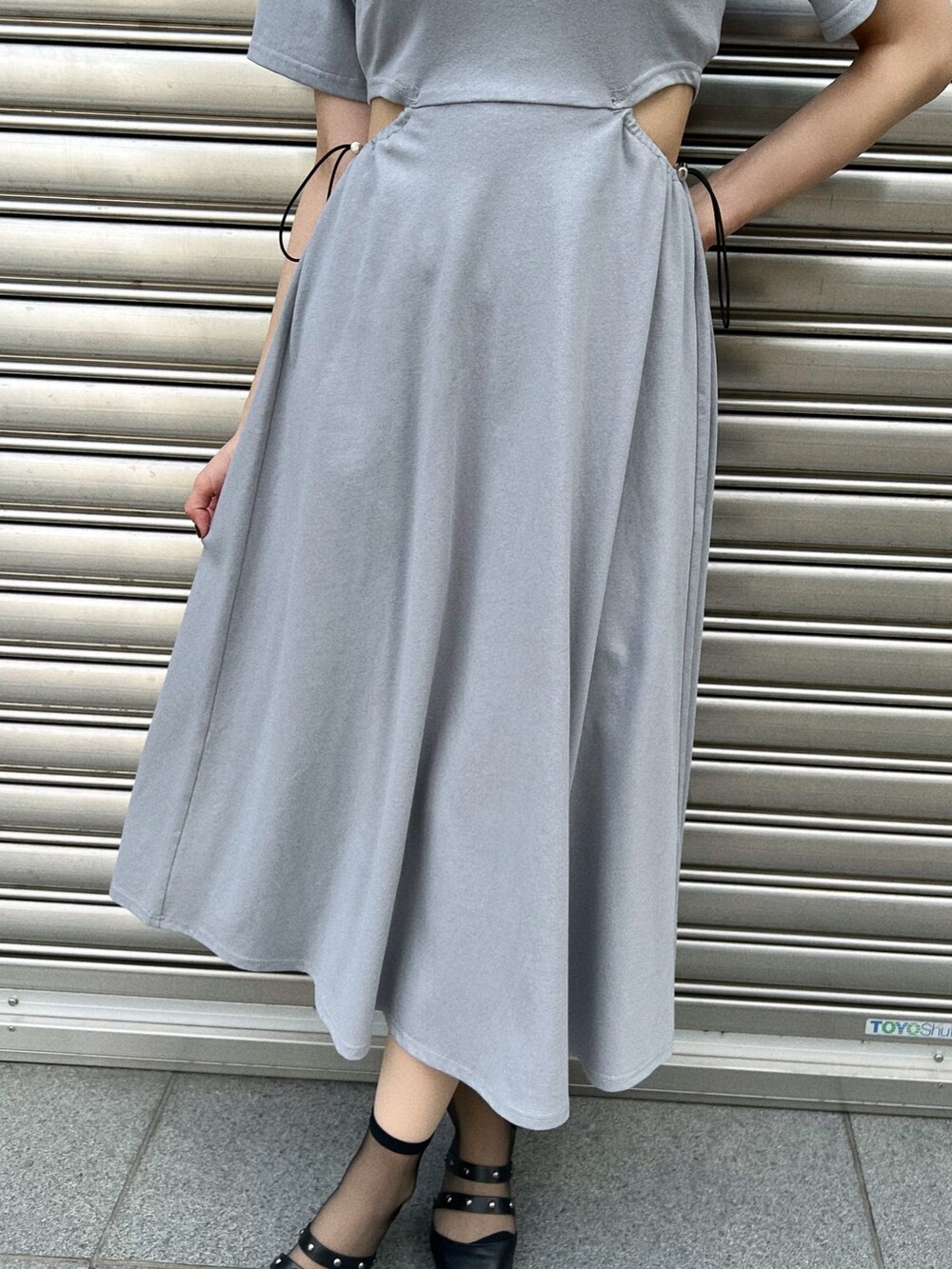 ブルー系のワンピース、ブルー系のハンドバッグ、ブラック系のパンプスを着用したレディースの夏コーディネートの5枚目の写真