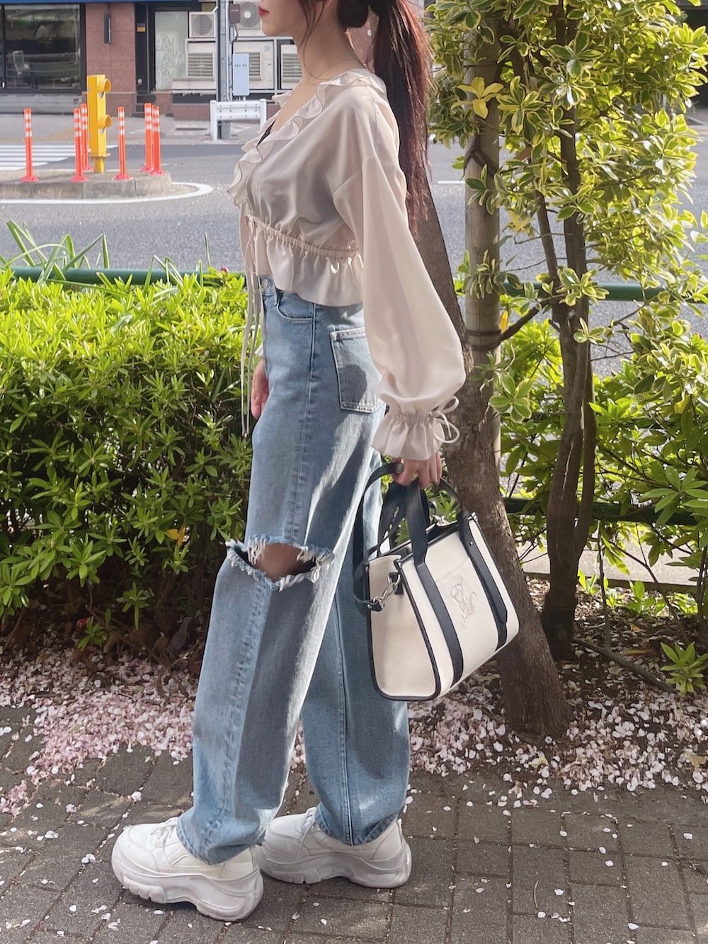 ブラック系のキャミソール、ホワイト系のシャツ/ブラウス、ブルー系のデニムパンツを着用したレディースの春コーディネートの3枚目の写真