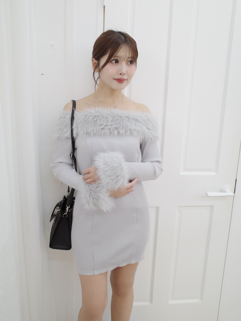 グレー系のワンピース、ブラック系のブーツ、ブラック系のハンドバッグを着用したレディースの秋コーディネートの7枚目の写真