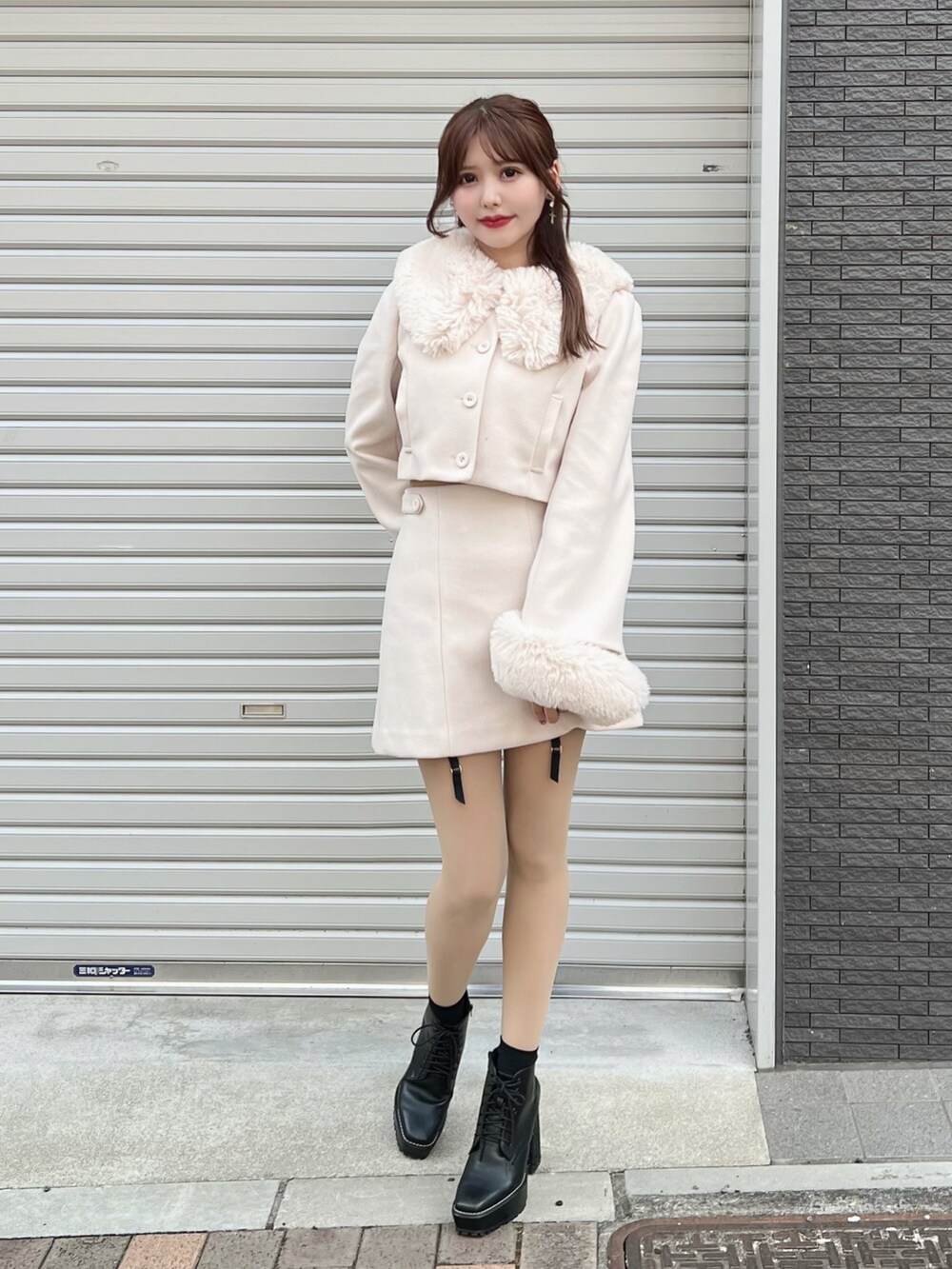 ホワイト系のセットアップ、ホワイト系のスカート、ブラック系のブーツを着用したレディースの秋コーディネートの2枚目の写真