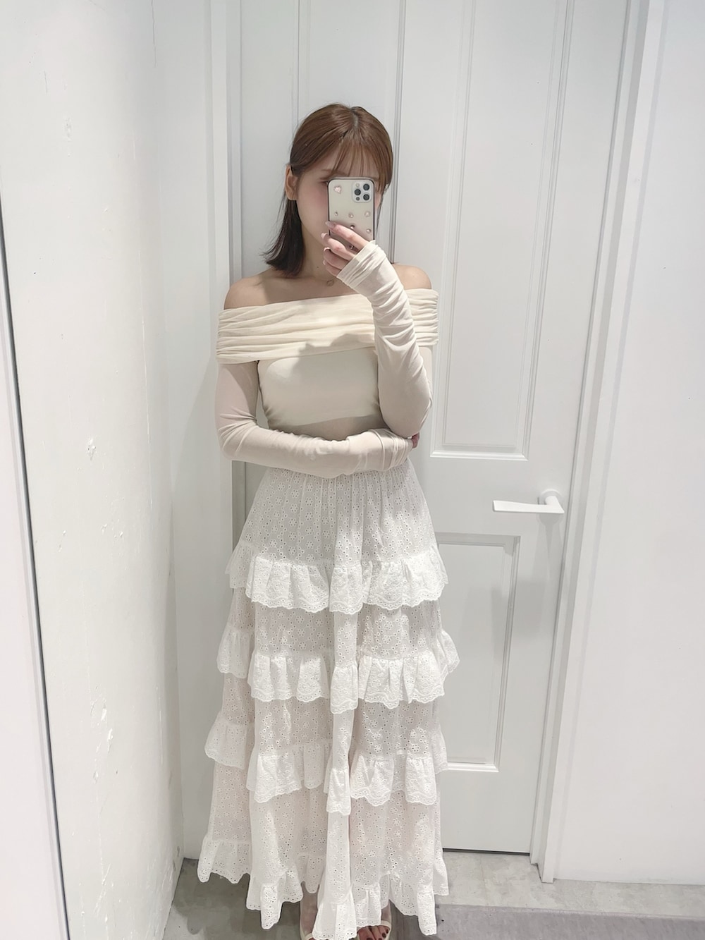 ホワイト系のスカート、ホワイト系のTシャツ/カットソー、ホワイト系のサンダルを着用したレディースの春コーディネートの3枚目の写真