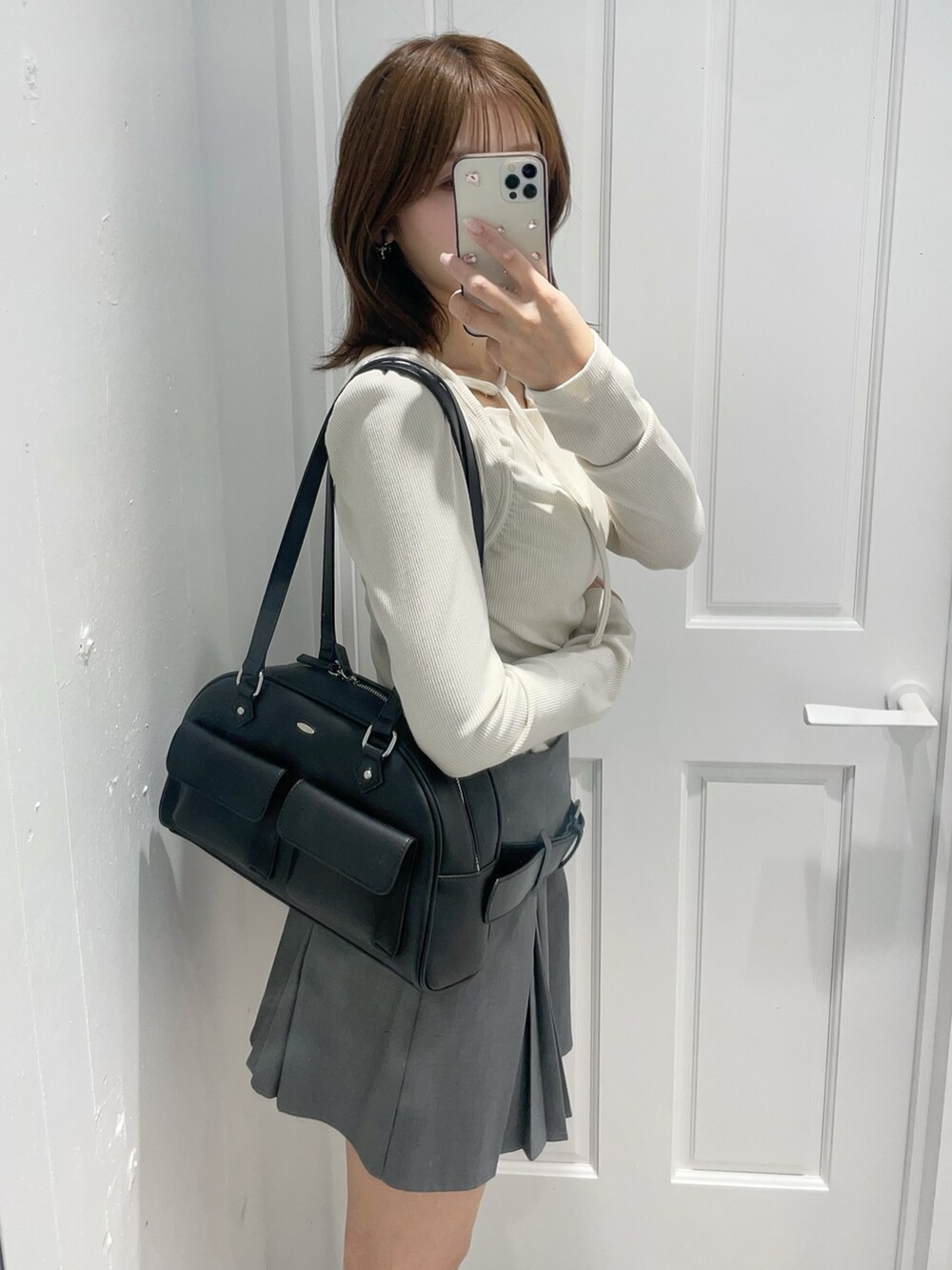 ホワイト系のTシャツ/カットソー、グレー系のスカート、ブラック系のボストンバッグを着用したレディースの春コーディネートの4枚目の写真