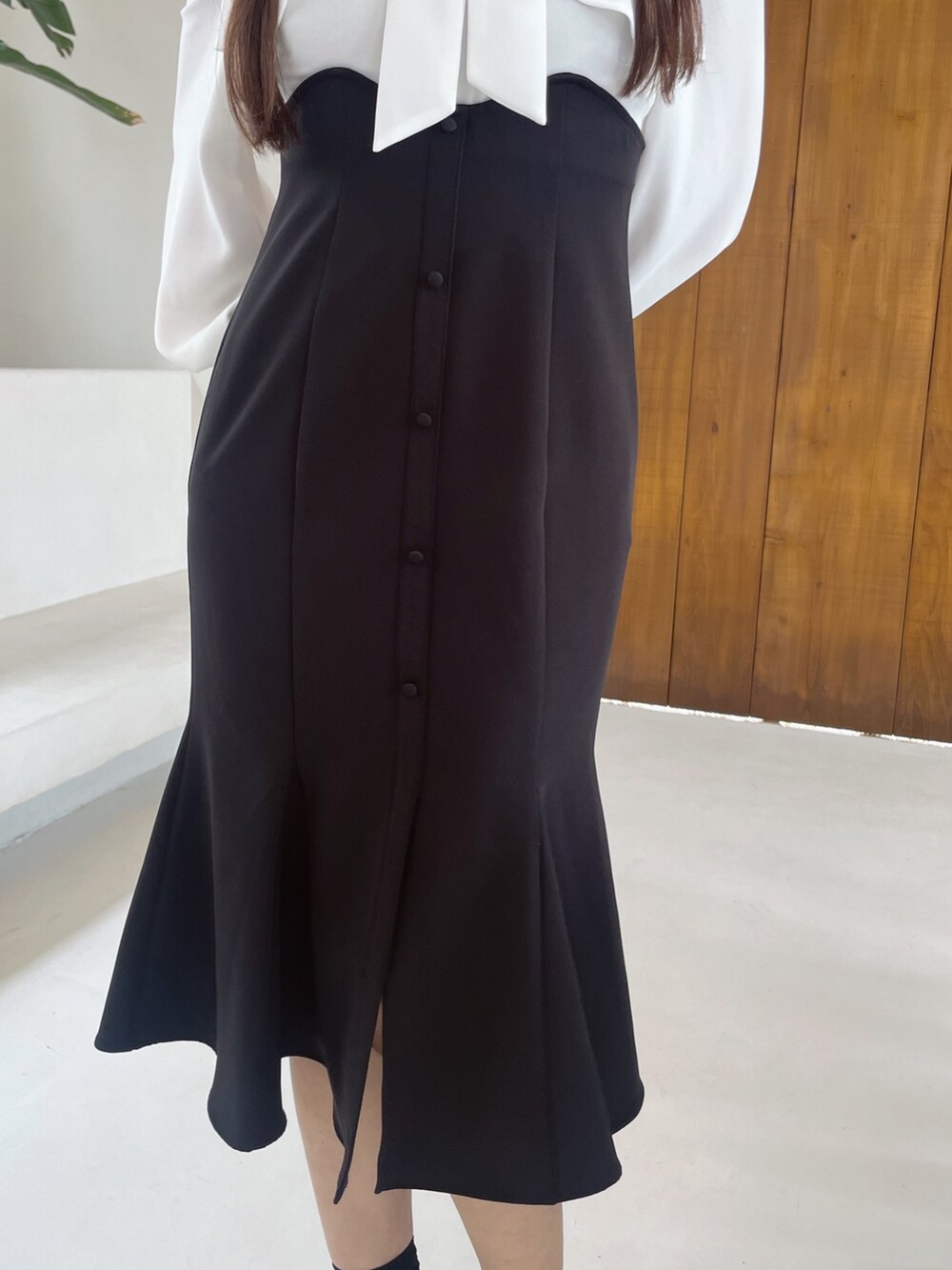 ブラック系のワンピース、ブラック系のショルダーバッグ、ブラック系のパンプスを着用したレディースの冬コーディネートの6枚目の写真