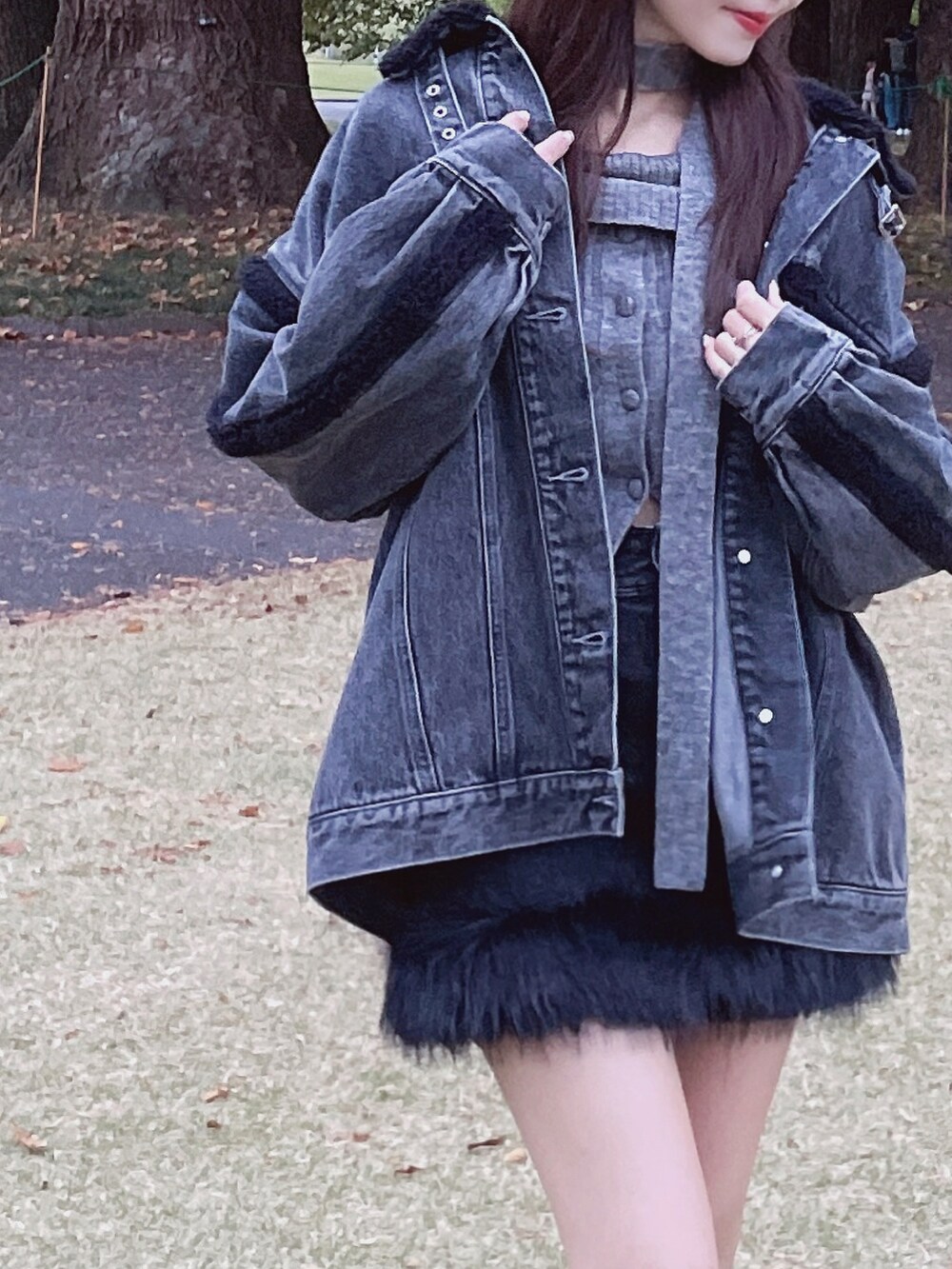 ブラック系のデニムジャケット、グレー系のニット/セーター、ブラック系のデニムスカートを着用したレディースの秋コーディネートの5枚目の写真