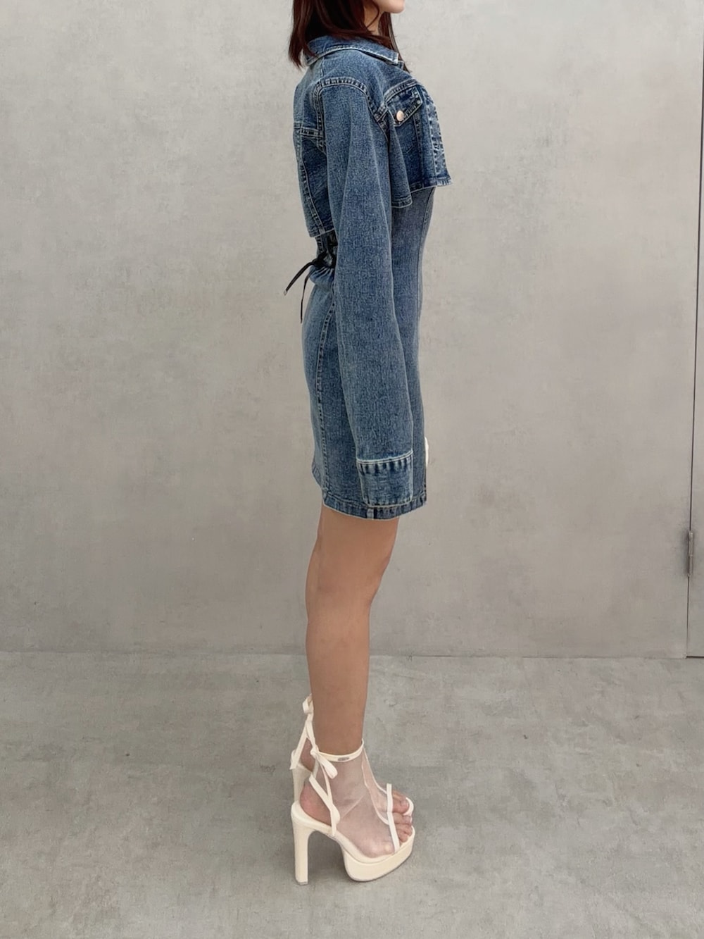 ブルー系のワンピース、ホワイト系のバックパック/リュック、ホワイト系のサンダルを着用したレディースの冬コーディネートの4枚目の写真