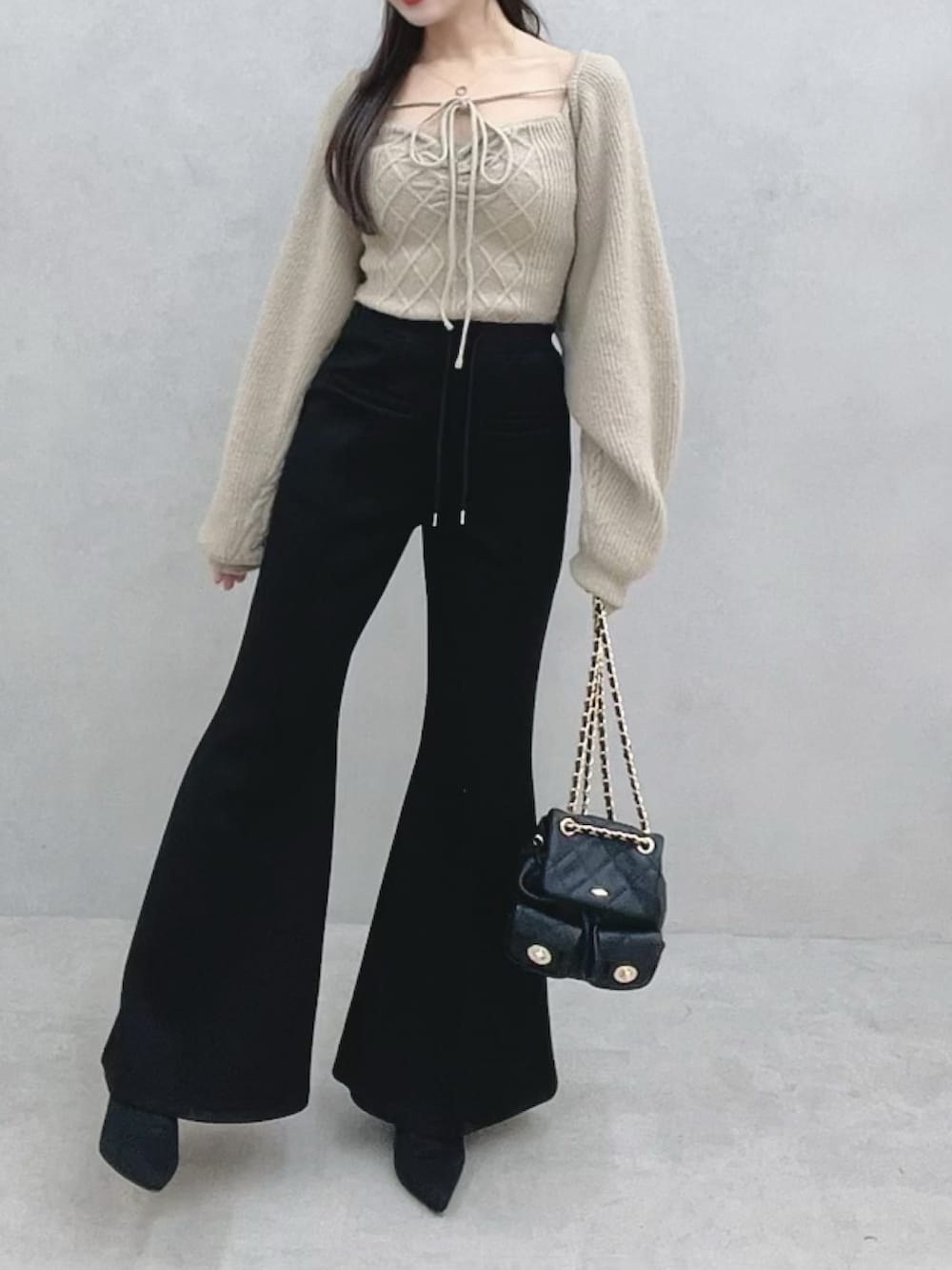 ベージュ系のニット/セーター、ブラック系のその他パンツ、ブラック系のブーツを着用したレディースの冬コーディネートの4枚目の写真