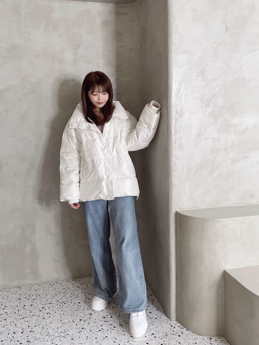 ホワイト系のダウンジャケット/コート、ブルー系のデニムパンツ、ホワイト系のスニーカーを着用したレディースの秋コーディネートの6枚目の写真