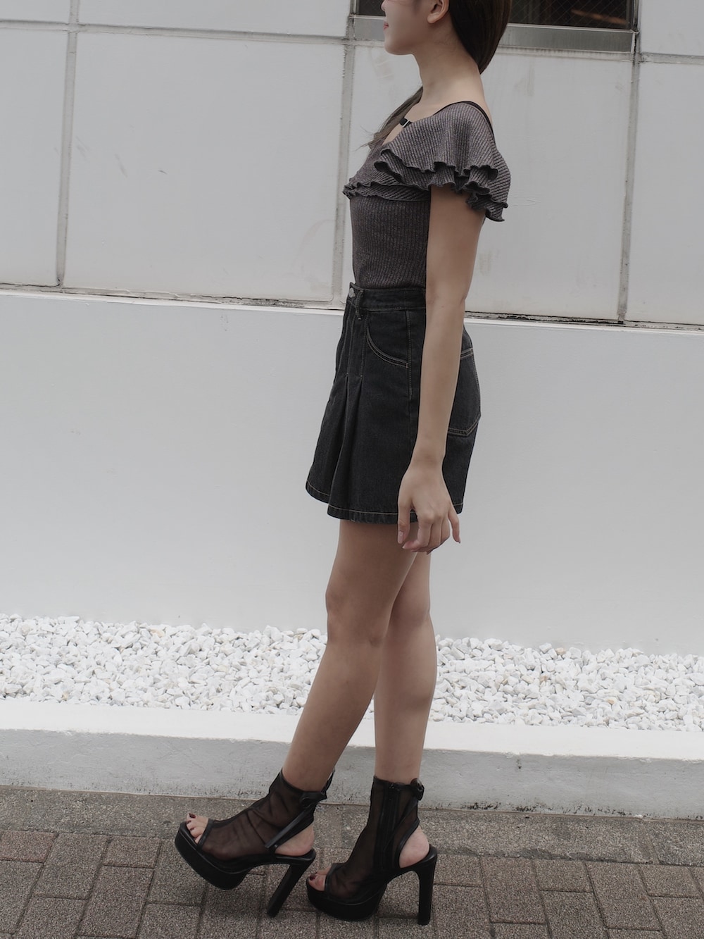 ブラック系のデニムスカート、ブラック系のサンダル、グレー系のTシャツ/カットソーを着用したレディースの夏コーディネートの4枚目の写真