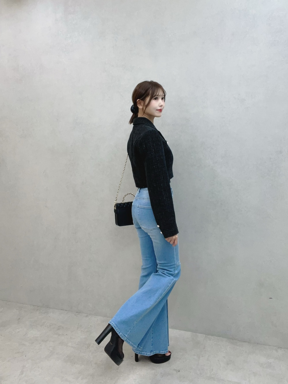 ブルー系のデニムパンツ、ブラック系のサンダル、ブラック系のテーラードジャケットを着用したレディースの秋コーディネートの4枚目の写真