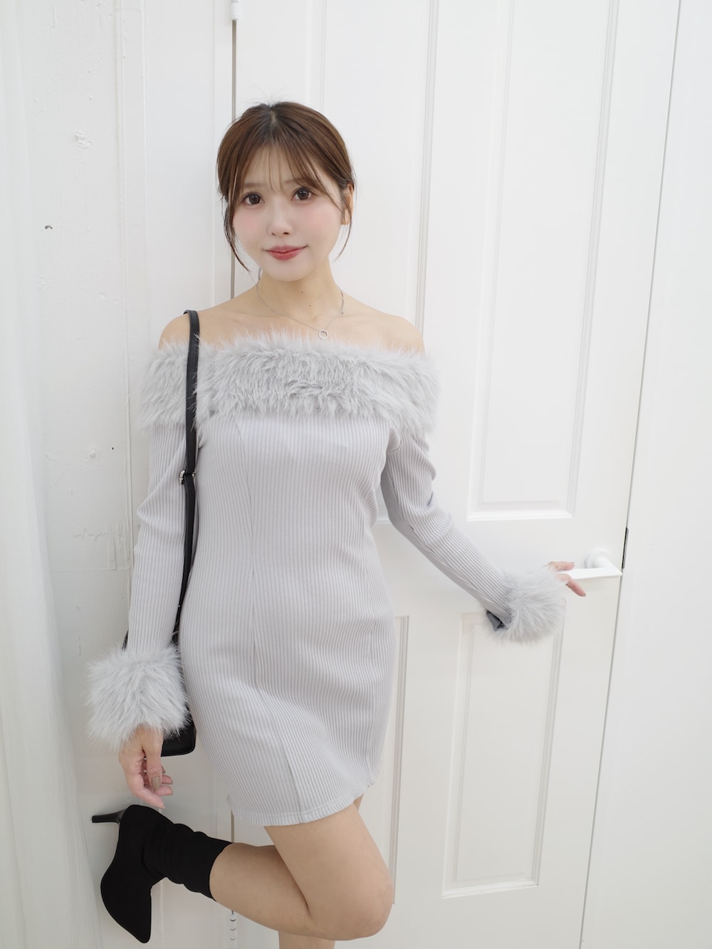 グレー系のワンピース、ブラック系のブーツ、ブラック系のハンドバッグを着用したレディースの秋コーディネートの5枚目の写真