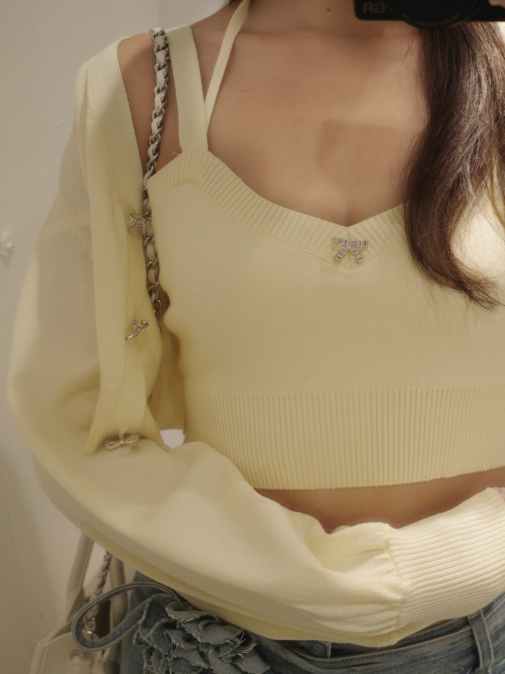 ブルー系のデニムパンツ、イエロー系のパンプス、イエロー系のニット/セーターを着用したレディースの夏コーディネートの3枚目の写真