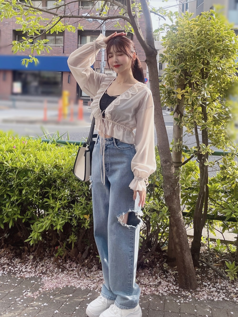 ブラック系のキャミソール、ホワイト系のシャツ/ブラウス、ブルー系のデニムパンツを着用したレディースの春コーディネートの2枚目の写真