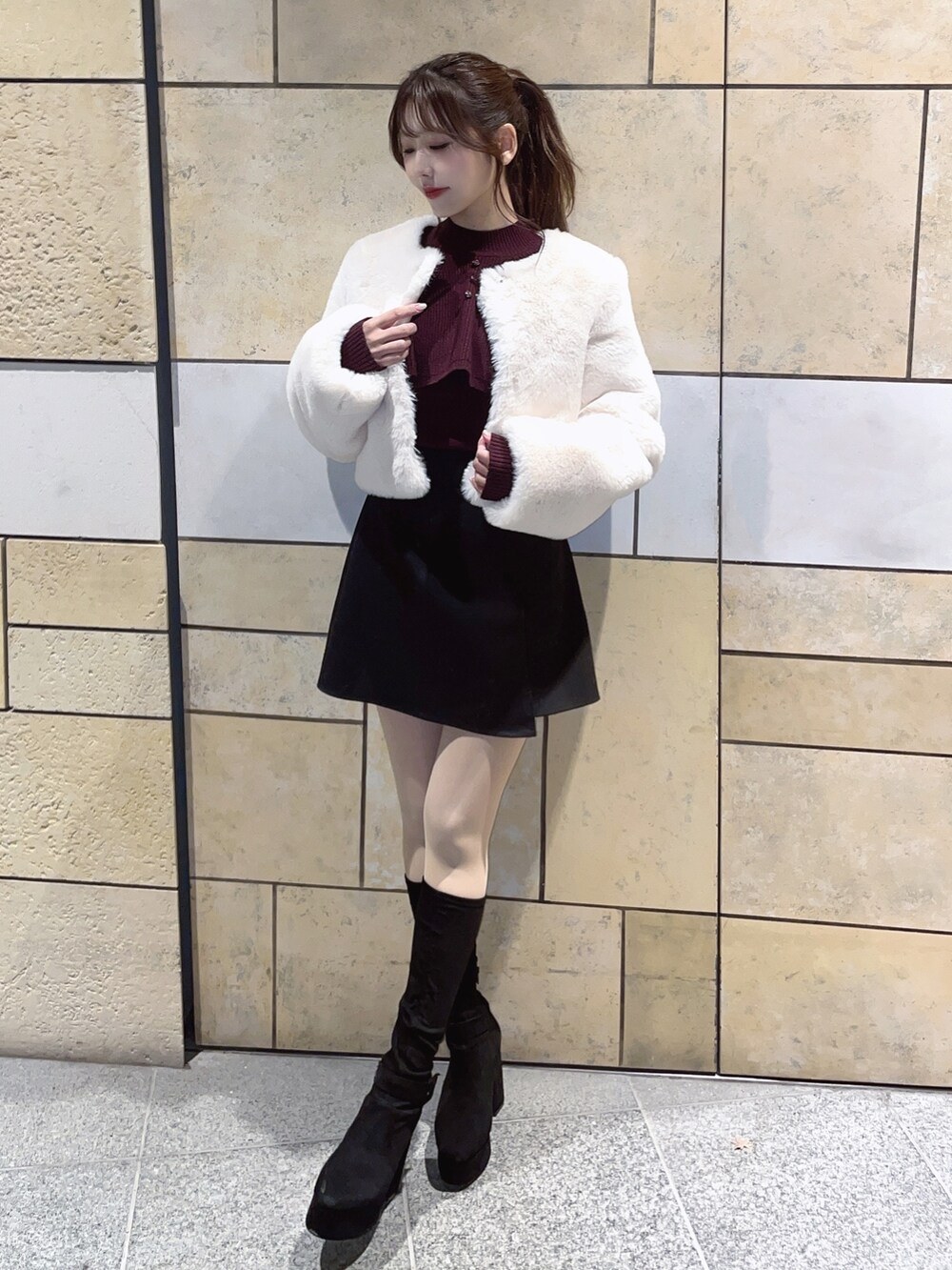 レッド系のニット/セーター、ブラック系のスカートを着用したレディースの冬コーディネートの4枚目の写真