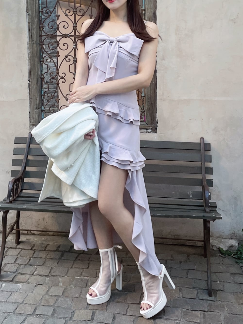 ホワイト系のテーラードジャケット、ホワイト系のサンダル、ピンク系のワンピースを着用したレディースの夏コーディネートの3枚目の写真