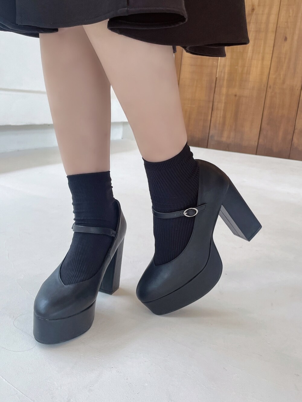 ブラック系のワンピース、ブラック系のショルダーバッグ、ブラック系のパンプスを着用したレディースの冬コーディネートの10枚目の写真