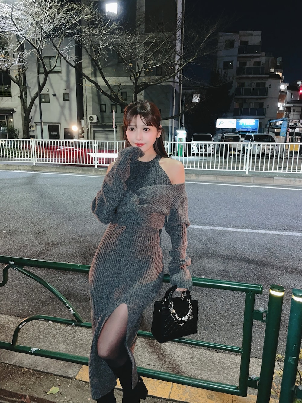 グレー系のワンピース、ブラック系のハンドバッグ、ブラック系のブーツを着用したレディースの冬コーディネートの7枚目の写真