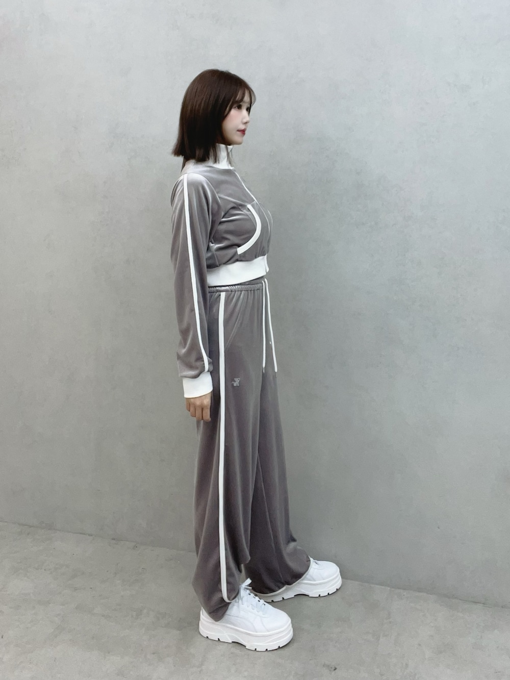 グレー系のブルゾン、グレー系のその他パンツ、ホワイト系のスニーカーを着用したレディースの秋コーディネートの3枚目の写真