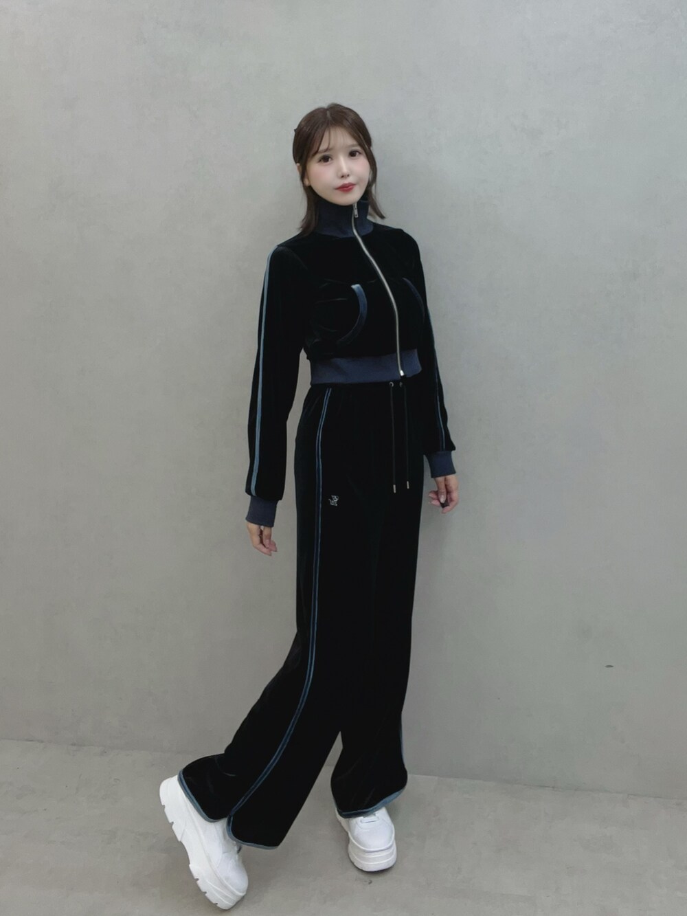 ブラック系のブルゾン、ブラック系のその他パンツ、ホワイト系のスニーカーを着用したレディースの秋コーディネートの2枚目の写真