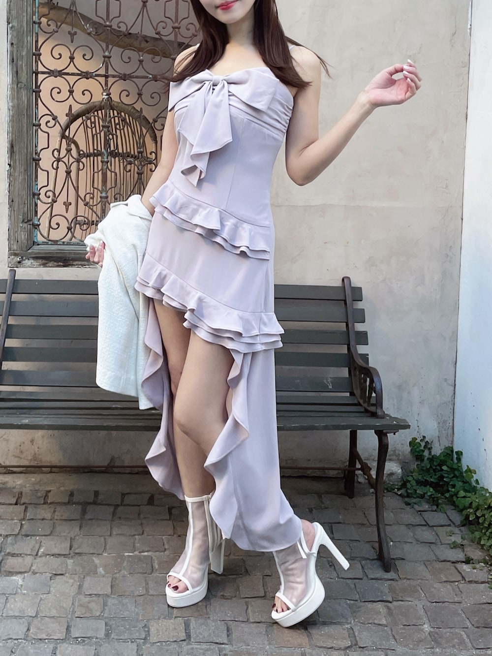 ホワイト系のテーラードジャケット、ホワイト系のサンダル、ピンク系のワンピースを着用したレディースの夏コーディネートの2枚目の写真