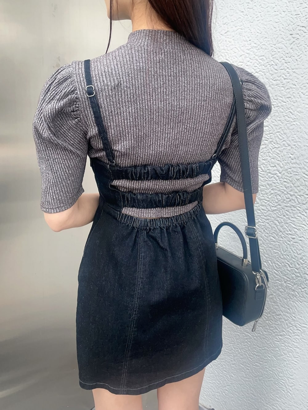 グレー系のニット/セーター、ブラック系のジャンパースカート、その他のサンダルを着用したレディースの春コーディネートの6枚目の写真