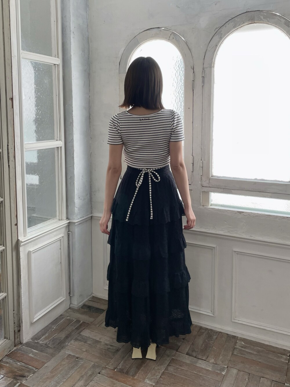 ブラック系のスカート、イエロー系のパンプス、その他のTシャツ/カットソーを着用したレディースの春コーディネートの4枚目の写真