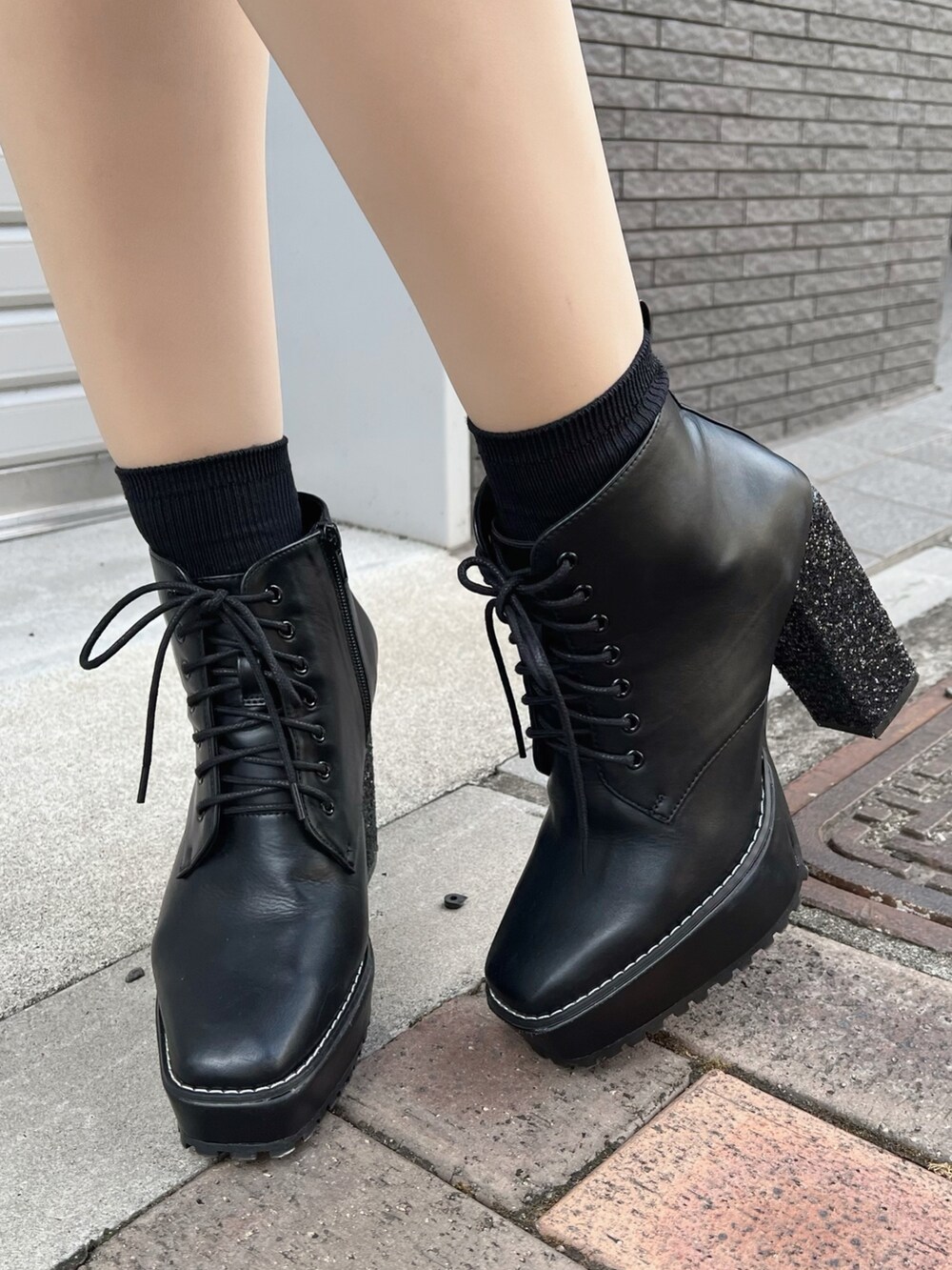 ホワイト系のセットアップ、ホワイト系のスカート、ブラック系のブーツを着用したレディースの秋コーディネートの10枚目の写真