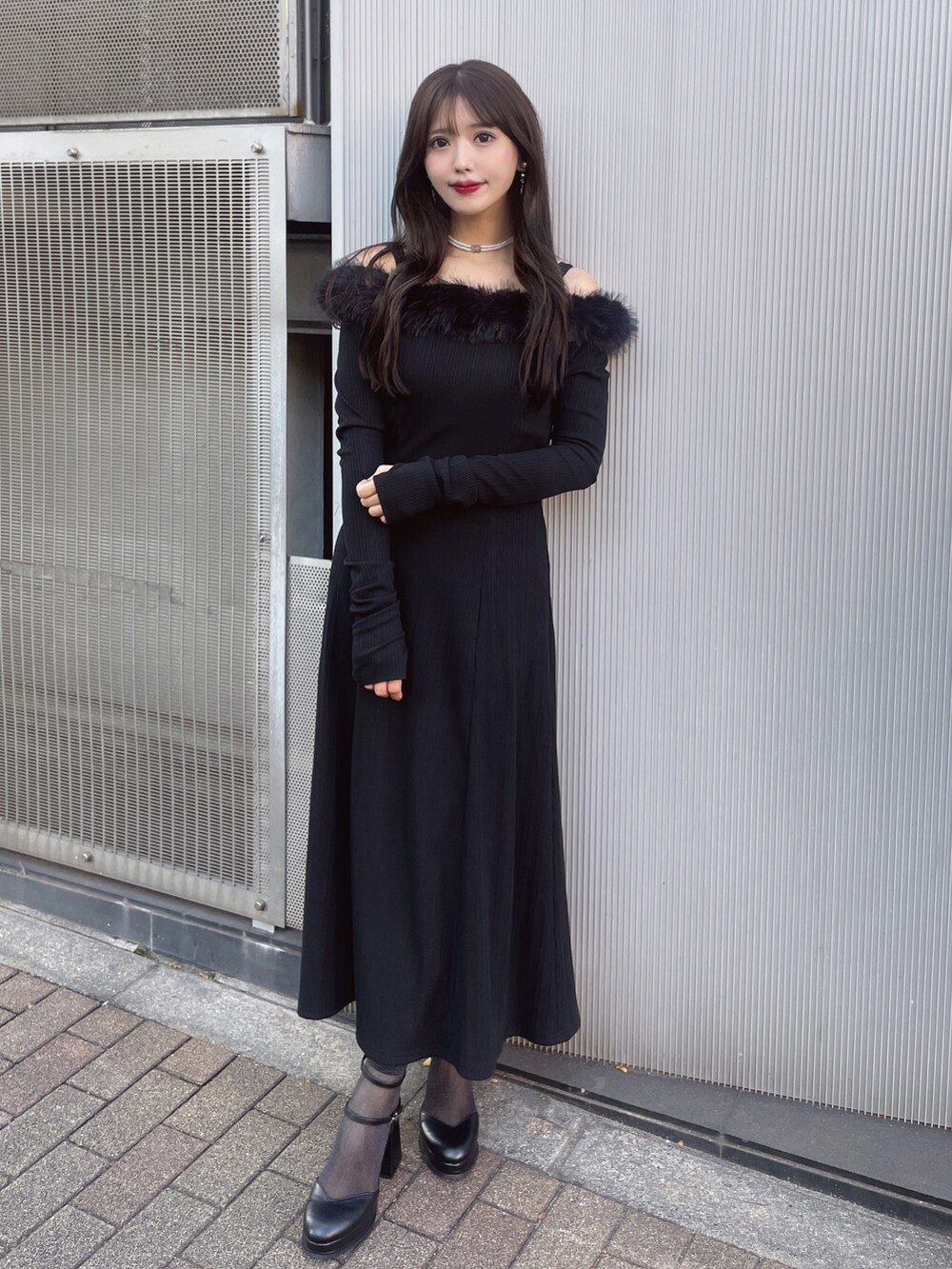 ブラック系のワンピース、ブラック系のパンプス、ホワイト系のチョーカーを着用したレディースの秋コーディネートの2枚目の写真