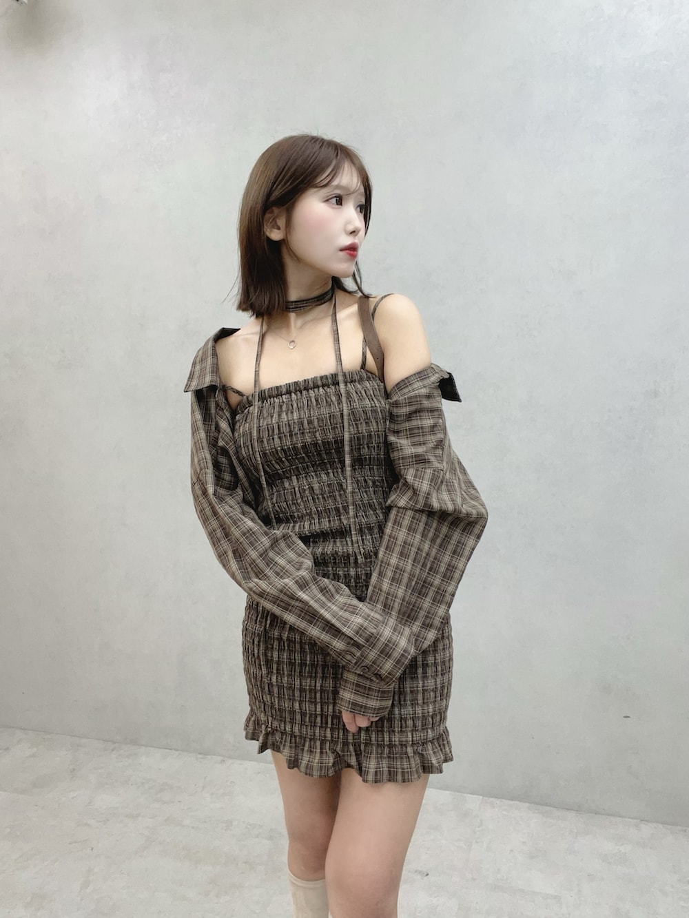 ブラウン系のワンピース、ブラウン系のショルダーバッグ、ホワイト系のブーツを着用したレディースの秋コーディネートの5枚目の写真