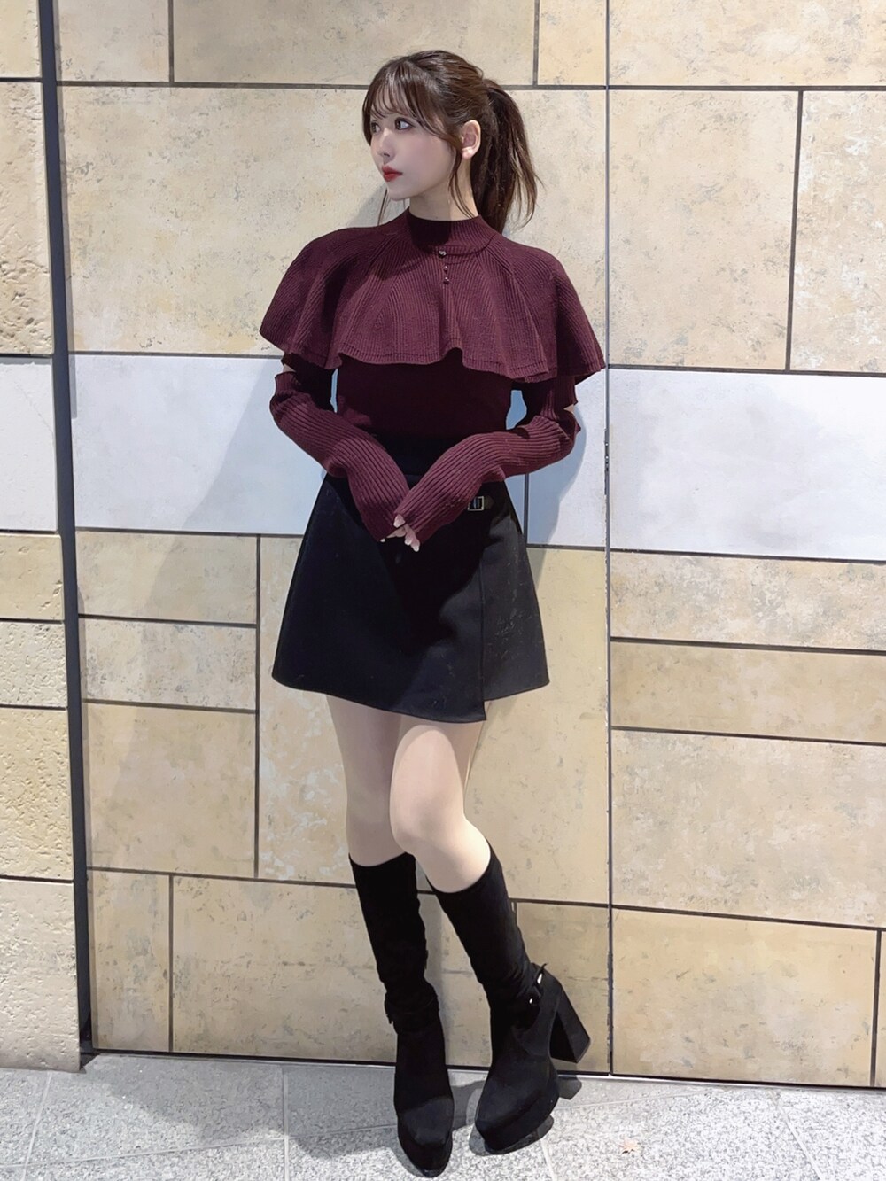 レッド系のニット/セーター、ブラック系のスカートを着用したレディースの冬コーディネートの2枚目の写真