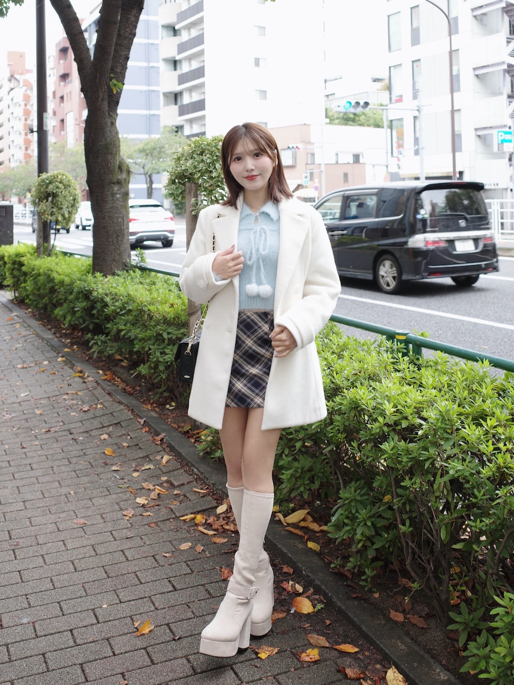 ブルー系のニット/セーター、ホワイト系のその他アウター、ブルー系のスカートを着用したレディースの秋コーディネートの2枚目の写真